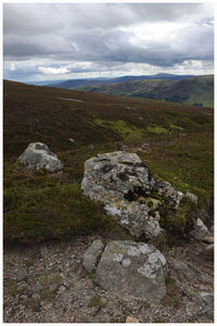 Scenic view of mountains against cloudy sky