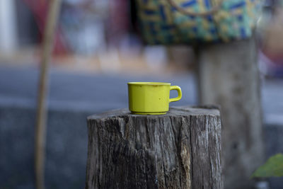 Close-up of yellow toy on wooden post