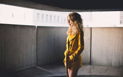 Woman standing against yellow wall