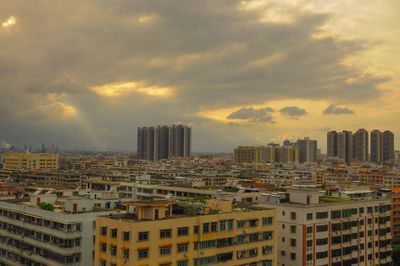 Buildings in city against sky during sunset