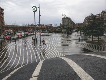 Man on road in city against sky