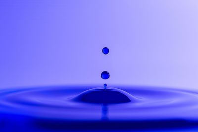 Close-up of water splashing against blue sky