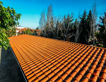 Tilt image of roof tiles on field against sky