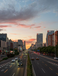 View of city street against cloudy sky