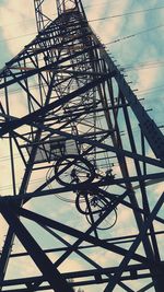 Low angle view of silhouette metal grate against sky