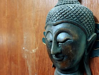 Close-up of buddha statue on wood