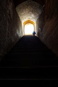 Low angle view of woman walking in tunnel