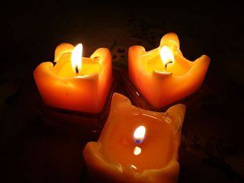 Close-up of illuminated tea light candles in darkroom