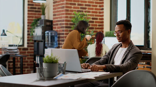 Male friends using laptop at office