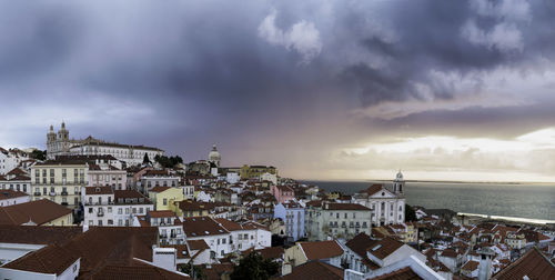 High angle view of town by sea against sky