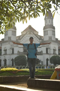 Portrait of young man standing against building