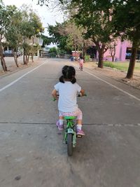 Rear view of girl riding bicycle