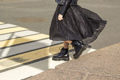 Part of clothing element of fashionable woman's wardrobe is chic black dress and boots.