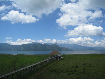 Scenic view of landscape by sea against sky