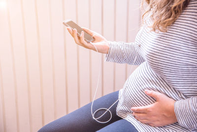 Midsection of woman using mobile phone