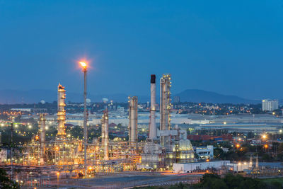 Illuminated factory against sky at night