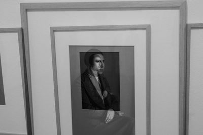 Portrait of woman standing against wall at home