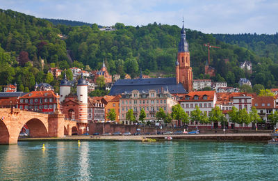 Arch bridge over river against buildings in city