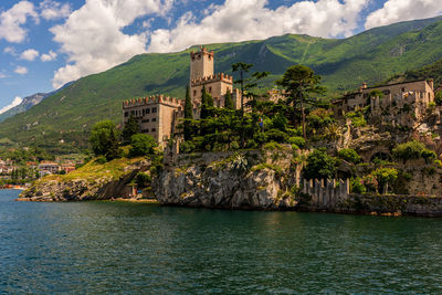 Buildings by sea against sky