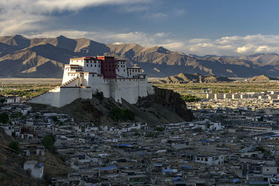 Buildings in town against cloudy sky