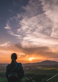 Rear view of woman looking at sunset