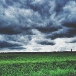 Scenic view of field against cloudy sky