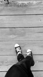 Low section of man standing on wooden floor