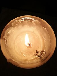 Close-up of illuminated lamp over black background