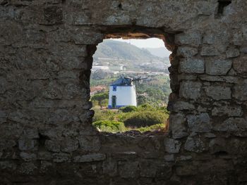 Old factory seen through stone wall hole