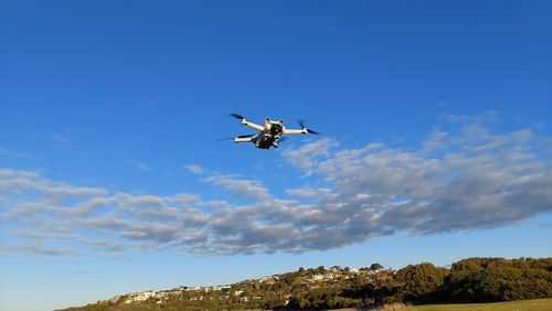 Low angle view of airplane flying against clear blue sky