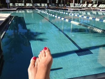 Low section of woman by swimming pool