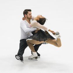 Man and woman performing during figure skating against white background