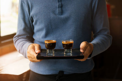 Close-up of man holding wine glasses