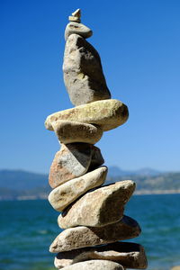 Close-up of stack of statue against blue sea