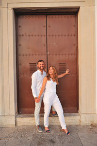 Happy young couple standing in city