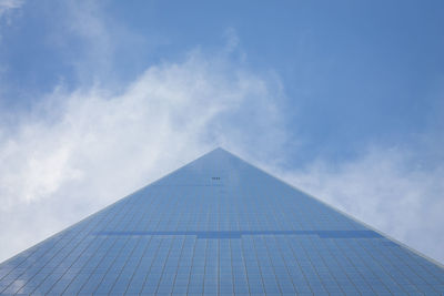 Low angle view of modern building against cloudy sky