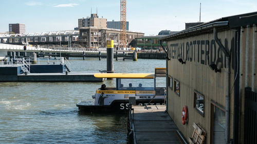 Boats moored at harbor against sky