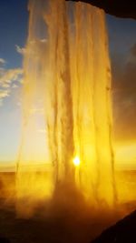 Close-up of yellow light against sky at sunset