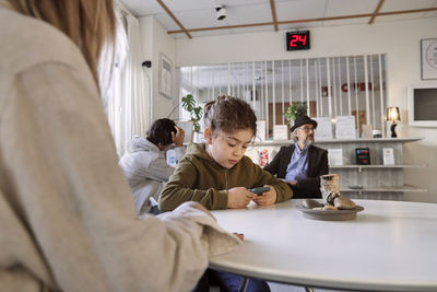 Girl in waiting room using cell phone