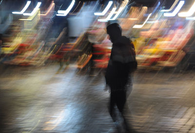 Blurred motion of people walking on street at night