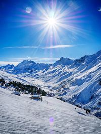 Sun shining through clouds over mountain