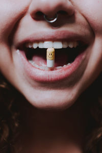 Portrait of woman holding capsule in mouth