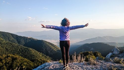 Full length of woman standing on mountain against sky