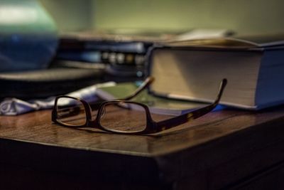 Close-up of eyeglasses by book on table