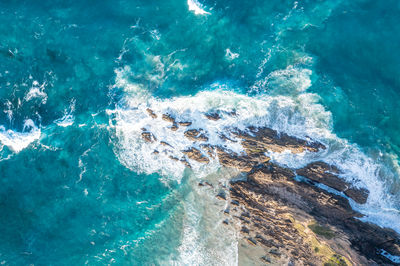 Aerial view ocean rocks with wave pattern white foam. travel and recreation. byron bay australia.