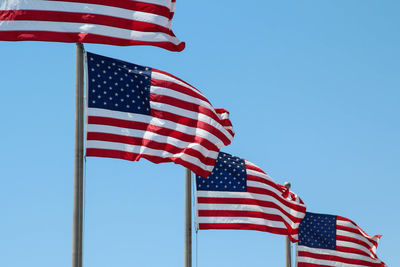 Low angle view of american flag against blue sky