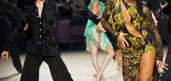 Midsection of man and woman dancing at event