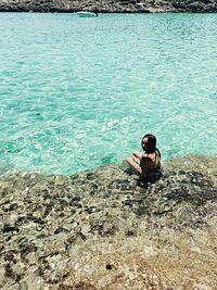 Rear view of man sitting on beach