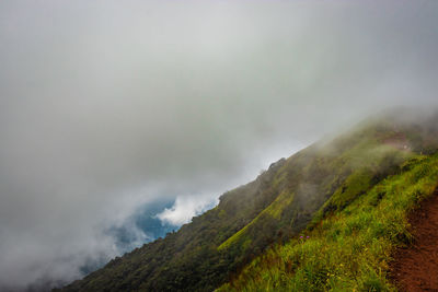 Mountain with green grass and thick clouds 