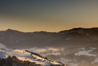 Scenic view of mountains against clear sky during sunset